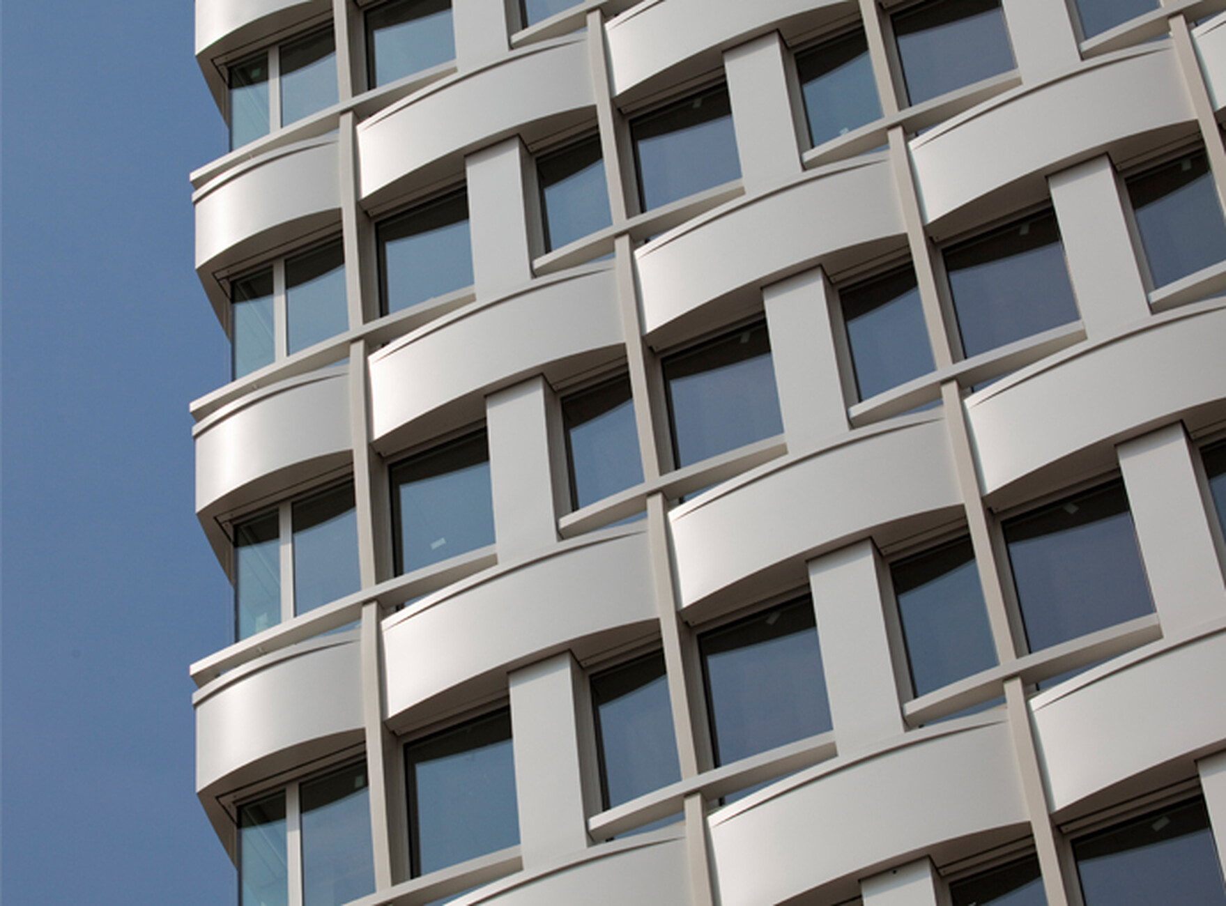 Für die Fassade des Agfa-Hochhauses wurden Brüstung, Pfeiler und Tragwerk von Hild und K als ineinander verwobene Bänder eines Gewebes aufgefasst.