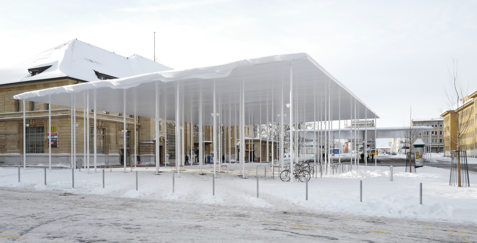 Zwei dünne Metalldächer von Frundgallina Architekten über dem Bahnhofsvorplatz in La-Chaux-de-Fonds