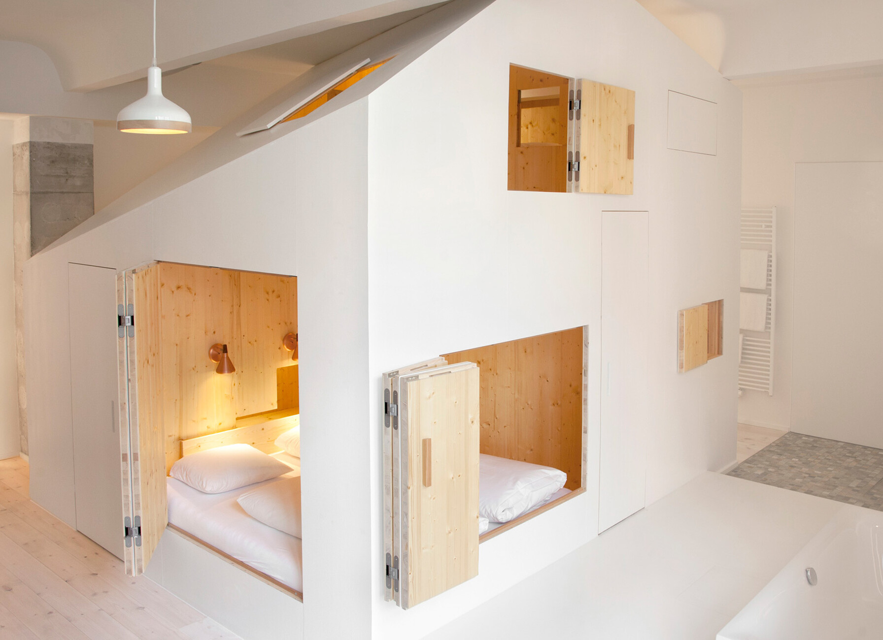 The danish architect Siguard Larsson inserted a two-storey living cube into two rooms of the hotel Michelberger.