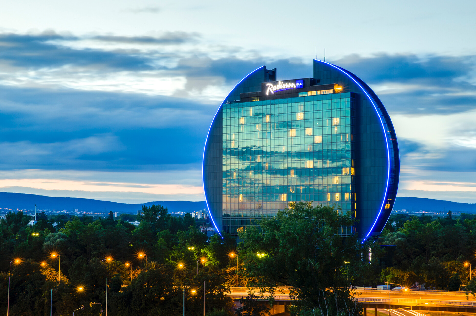 Die Kontur des knapp 100 Meter hohen Gebäudes leuchtet dank einer linearen LED-Leuchte Monochrome Tube nachts bis in die weite Ferne.