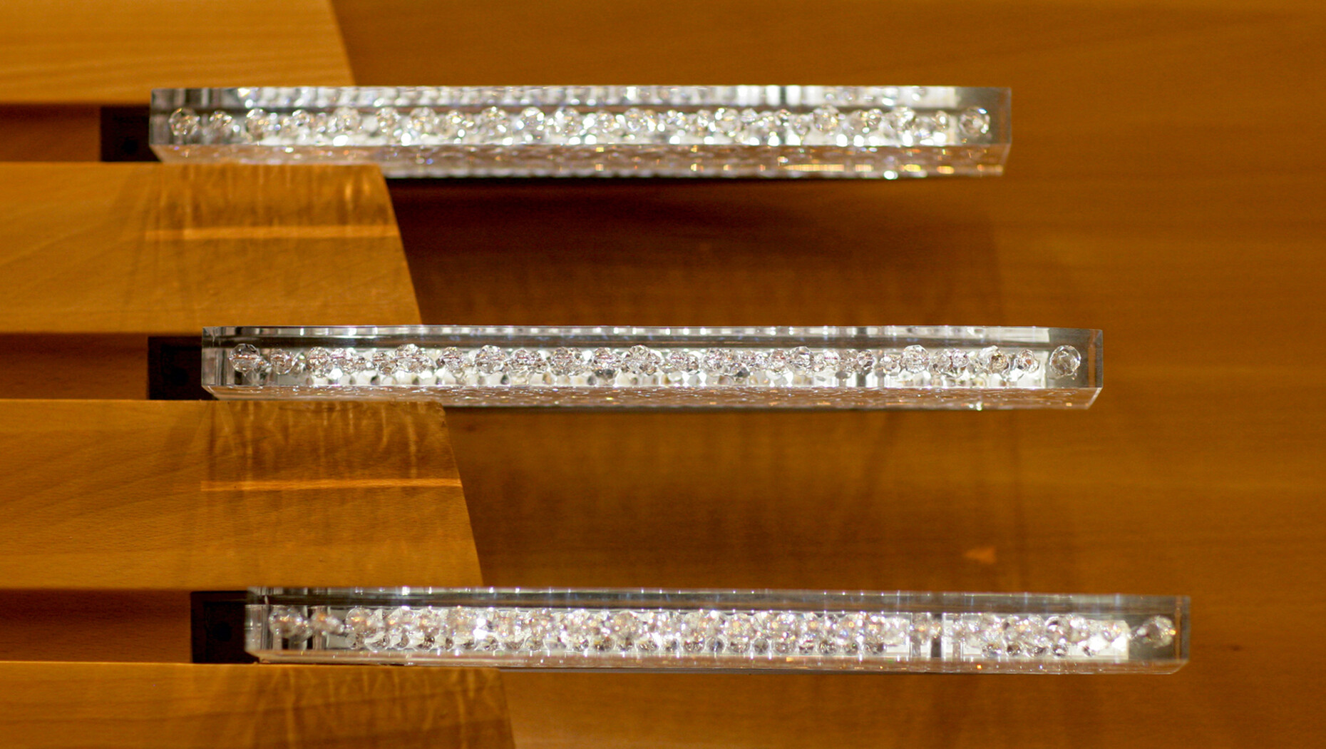 Diamond Schmitt Architects have inset flat lighting elements courtesy of Swarovski to create a refined accent in the wooden panels for the three galleries.