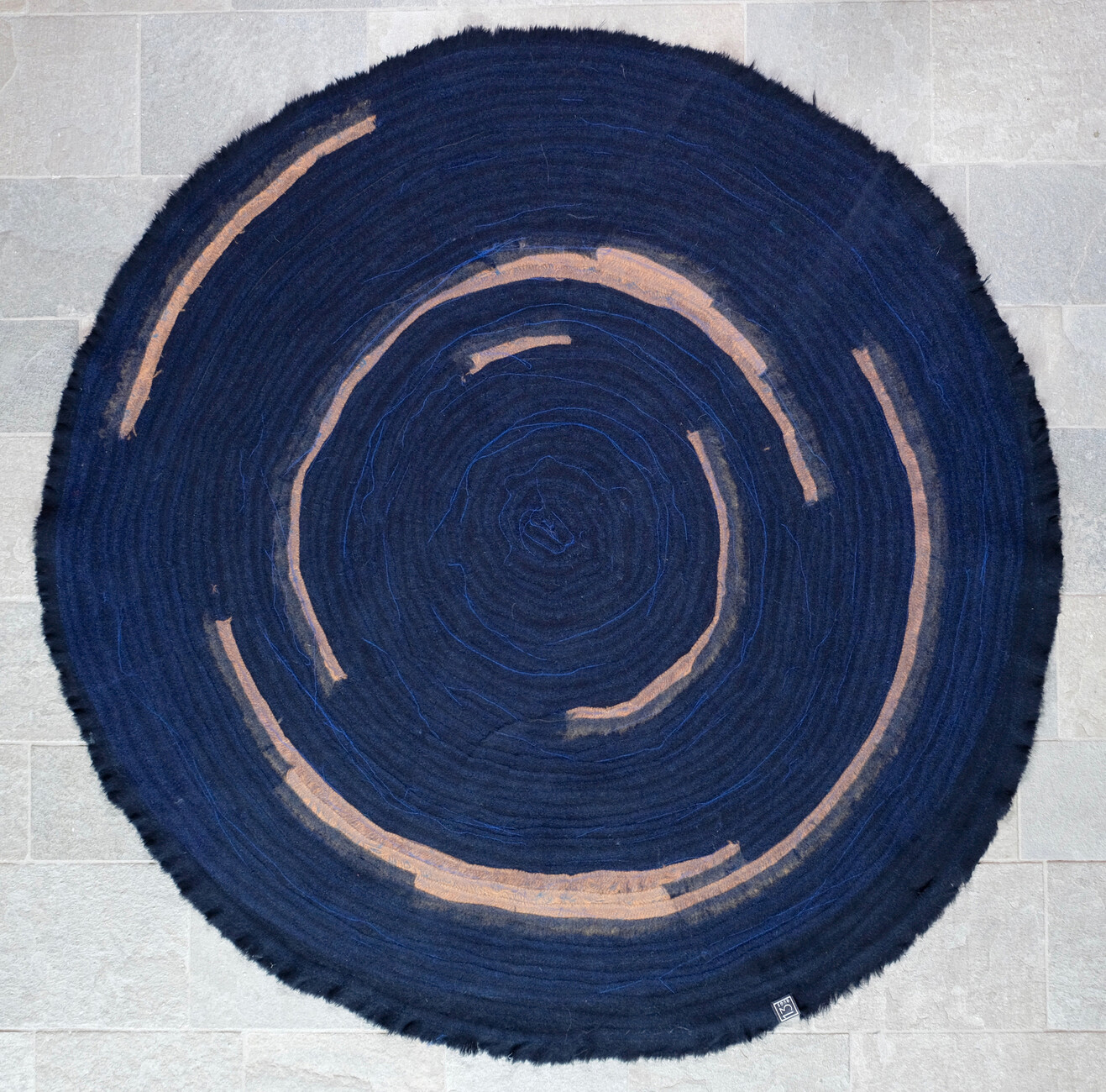 Der Teppich "Deep Blue 01" hat einen Durchmesser von 230 cm und setzt farbliche Highlights in Cognac.