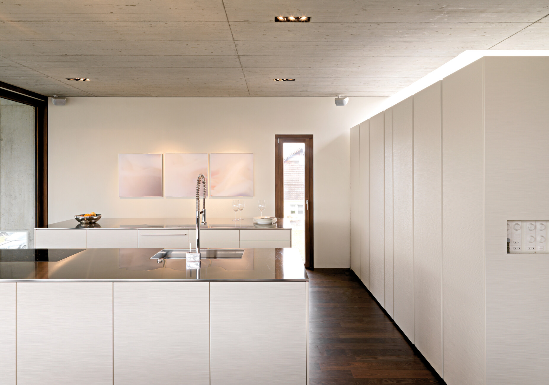 Für den Mittelpunkt des Hauses hat man parallel zum langen Esstisch zwei gleichgroße Küchenblöcke von Leicht Küchen platziert.