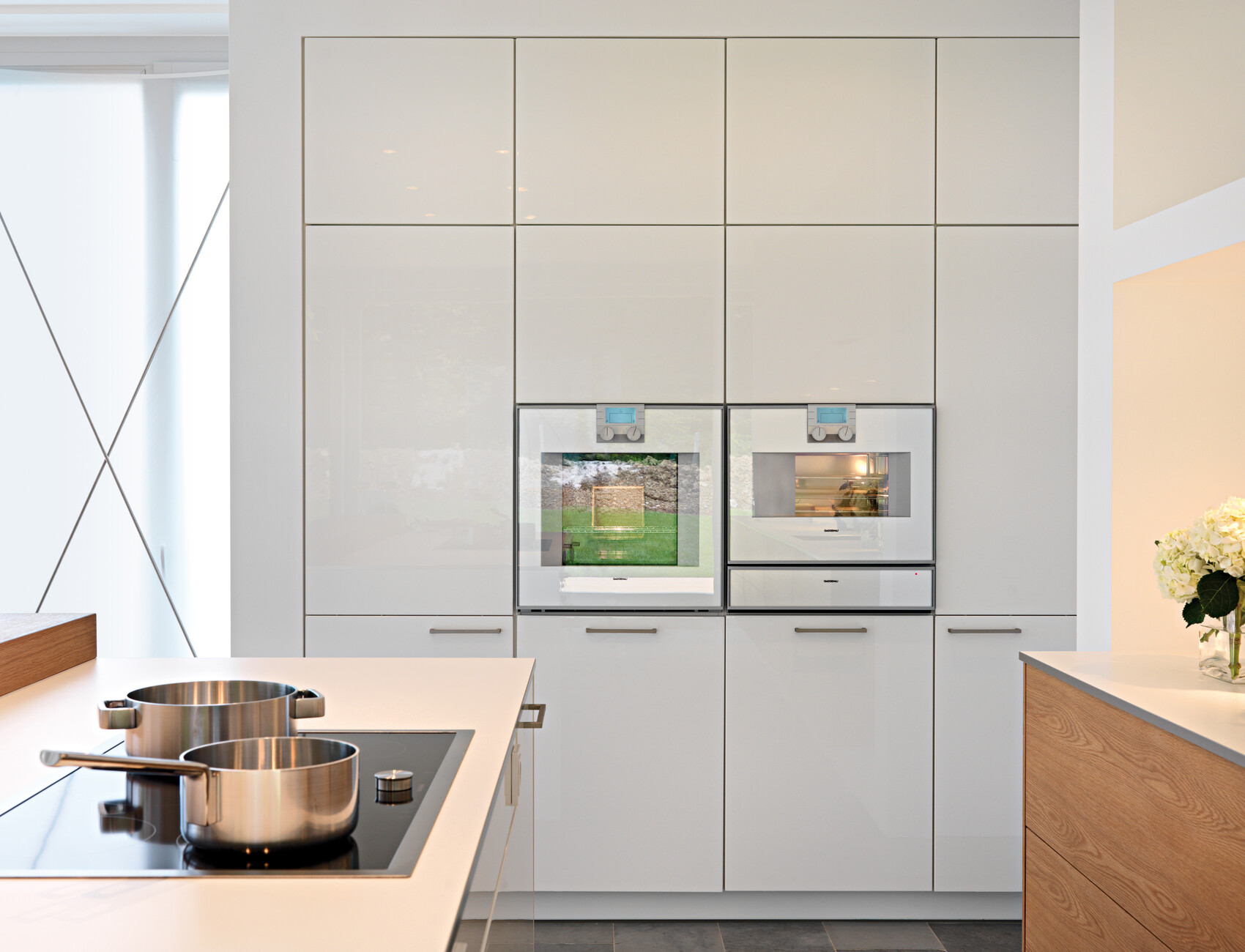 All the electrical appliances are installed flush into the upper row of fitted cupboards or embedded in the masonry to form the kitchen island and create an ergonomic worktop.