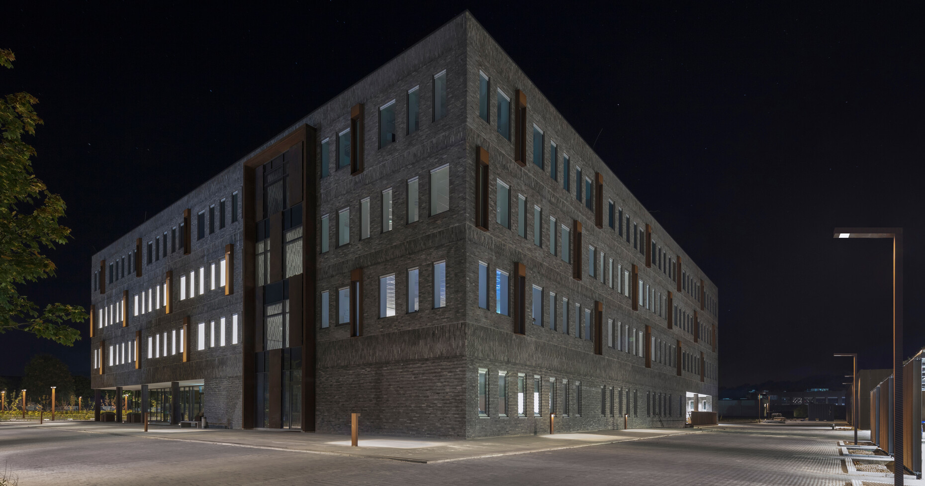 Årstiderne Arkitekter bauten einen Firmensitz für Jyske Bank in Silkeborg, Dänemark, in den dank zahlreicher Fenster viel Licht fällt. Die Umgebung des Gebäudes beleuchten Außenleuchten von ewo.