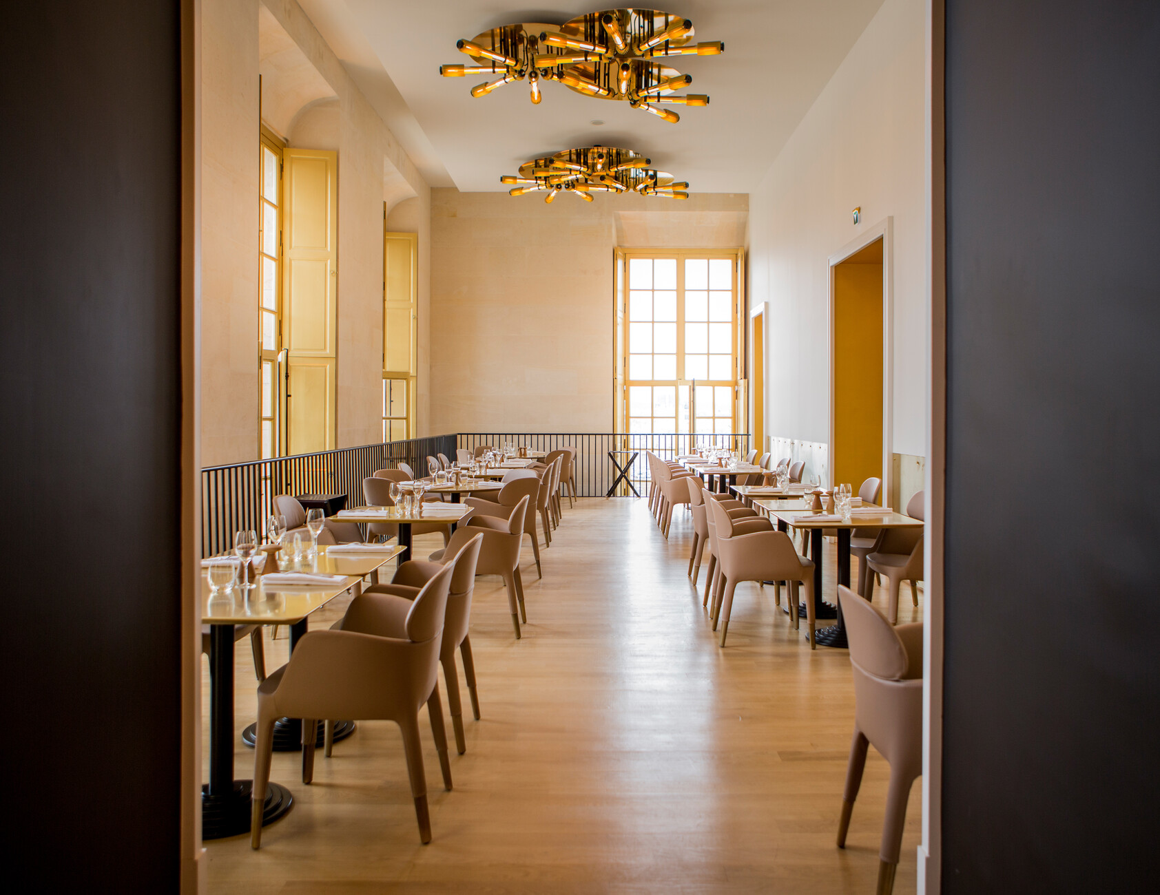 The Baroque rooms with an inlaid parquet floor and paneled walls get through the organically shaped “Ester 691” chairs by Pedrali a modern touch.