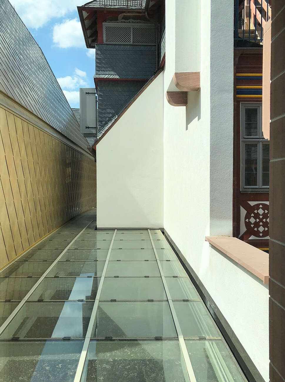 ​Glass roof above the Archaeological Garden. To the left of the town house, to the right the reconstructed buildings on the market.​