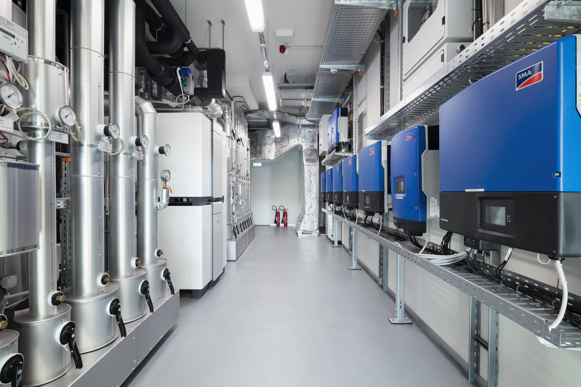 Schaltzentrale: Großwärmepumpen sorgen im Energy Campus für Heizung, Kühlung und Warmwasserbereitung. Ebenfalls zu sehen ist auf der rechten Seite der Wechselrichter der 120 kWp-Photovoltaikanlage, die auf dem Dach und in der Fassade installiert ist.